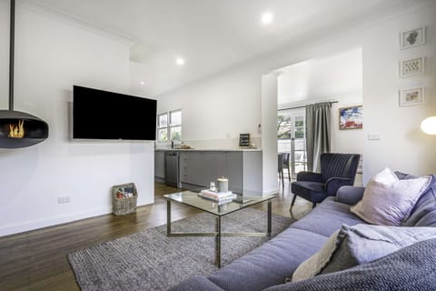 Open plan lounge area with fireplace, split system hearting and cooling and Smart TV