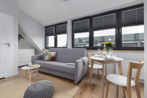 A modern living and dining area with large windows, a cozy sofa, and a stylish table setting.