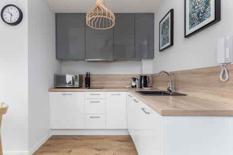 A fully equipped kitchen with white cabinetry and wooden accents for a functional yet elegant design.