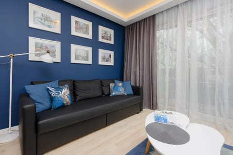 A stylish living room with a dark blue accent wall, modern sofa, and elegant decor, creating a sophisticated ambiance.
