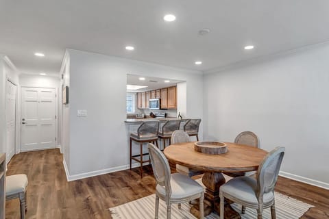 - Intimate dining space with round table for four and additional barstool seating
- Light walls, recessed lighting, and wood floors blend casual and elegant comfort
- Open kitchen pass through keeps conversation flowing between rooms