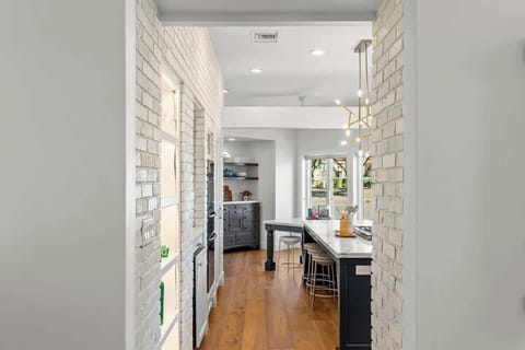 Modern kitchen with a large island and natural wood flooring.