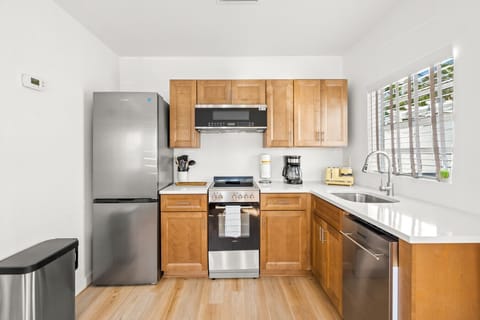 Siesta Key Beach Retreat kitchen with stainless-steel appliances, warm wood cabinets, and bright finishes—ideal for easy, stylish coastal cooking.