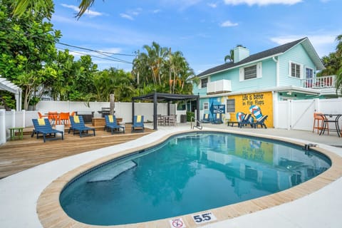 Siesta Key Beach exclusive guest pool with blue chairs, vibrant orange touches, and palm-shaded privacy—styled for laid-back dips and coastal ease.