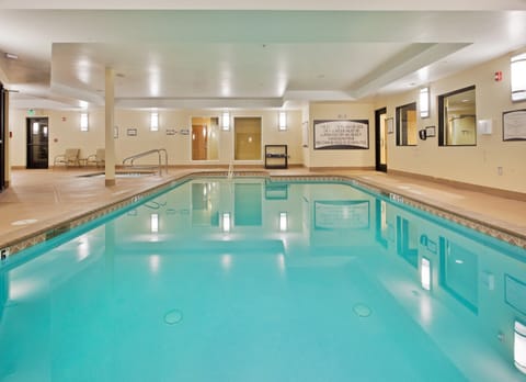 Indoor pool with clear water and surrounding lounge seating.