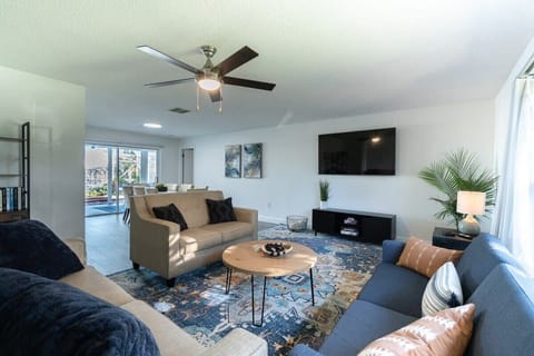Bright living room with modern seating and a large wall-mounted television