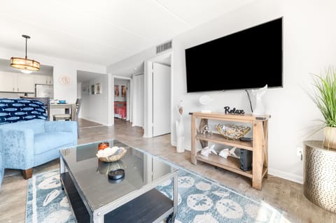 Open-concept living space with a flat-screen TV, center table.