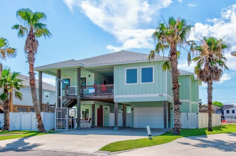 Charming coastal home with tropical palm trees and spacious covered parking in a sunny beachside neighborhood.