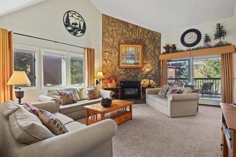 Enjoy the open-space living area as you relax in one of the three cozy sofas while taking in the high ceilings, impressive stone-finished fireplace, and views out the large windows.
