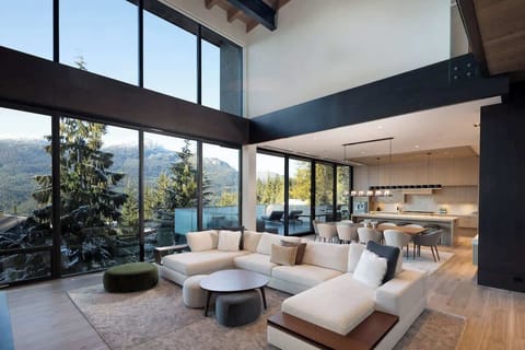 - Expansive living room with floor-to-ceiling mountain view windows  
- Cozy sectional seating bathed in natural light and open-concept design  
- Perfect blend of modern comfort and panoramic alpine scenery  
