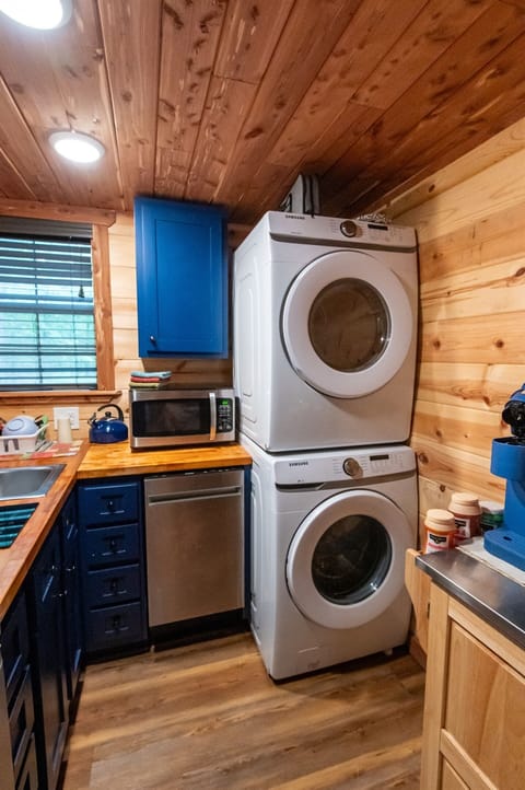 - Compact kitchen corner with washer dryer setup   - Blue cabinets and wood counters add cozy cabin charm   - Full convenience for extended forest stays forest cabin retreat