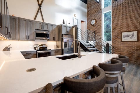 Your gourmet kitchen awaits with gleaming quartz counters, stainless appliances, and cozy bar seating perfect for morning coffee.