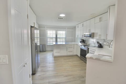 The fully remodeled kitchen boasts gorgeous cabinetry, white marbled quartz countertops and top of the line stainless steel appliances.