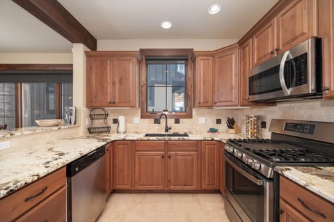 Your gourmet kitchen awaits with gleaming granite counters, premium appliances, and warm wood cabinetry—perfect for preparing memorable meals during your stay.
