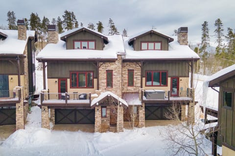 Mountain lodge with stone and timber construction nestled among snow-covered pines, offering authentic alpine architecture in a pristine winter setting.