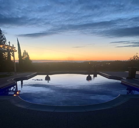 View of pool from pool house at sunset.

