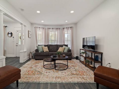 Spacious living area with comfy seating and TV view   - Decorative rug and soft lighting make it inviting   - Perfect for family movie nights or group hangouts