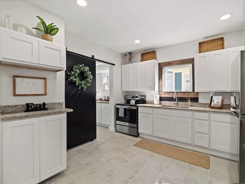 Bright kitchen w/ white cabinets, stainless stove & plenty of counter space