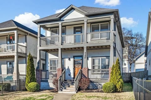 Stylish home with double porches and a fenced yard on a quiet street