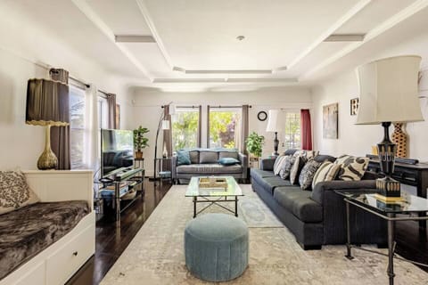 Spacious bright  living room, corner of daybed to left, coved ceilings with in-laid trim, flat screen tv