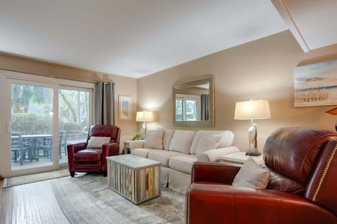 Sink into plush leather seating in your elegantly appointed living room, where warm lighting and patio views create the perfect retreat.