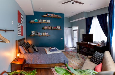 View of the entire room with TV, microwave, mini fridge, coffee maker, couch.