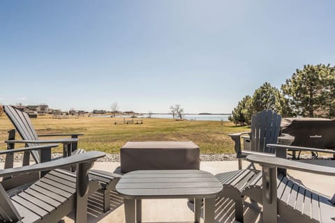 Outdoor seating with propane firepit, gas grill, and hot tub with lake view