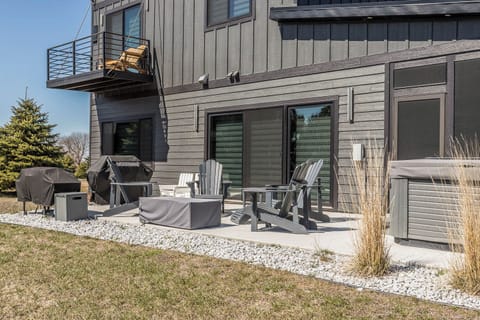 Outdoor seating with propane firepit, gas grill, and hot tub with lake view