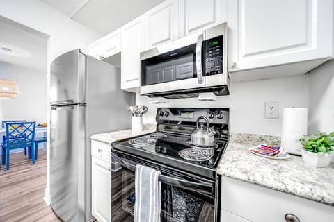 Fully stocked kitchen with glass top gas burner and oven and two door fridge