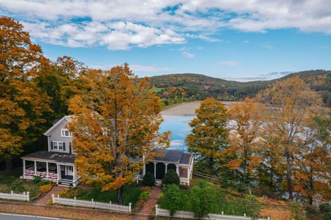 Aerial view of the historic Dewey House on Dewey Pond, surrounded by vibrant fall foliage
