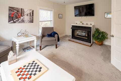 Cozy living room with a full‑size pull‑out sofa, a gas fireplace, and a selection of games — the perfect spot to unwind after exploring the Capital Trail.