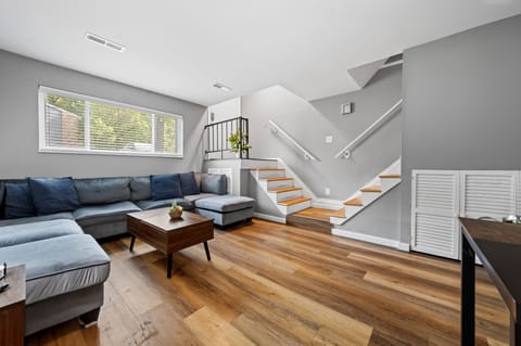 Living room; Unit entry way stairs on the left, and stairs leading upstairs on the right.