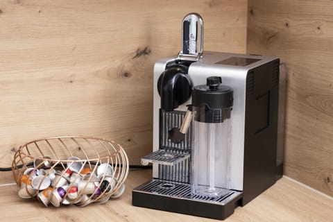 A close-up of a sleek coffee machine and a decorative bowl on a wooden countertop.





