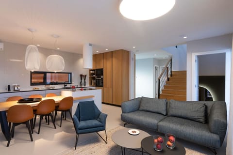 Living space with living room and kitchen and stairs leading to the second floor of this villa with pool