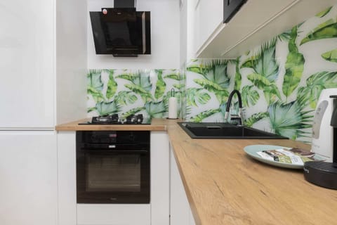 A compact yet functional kitchen with a sleek design and colorful backsplash.
