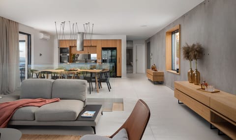 Living room with gray sofa, chairs and coffee table and kitchen with living area