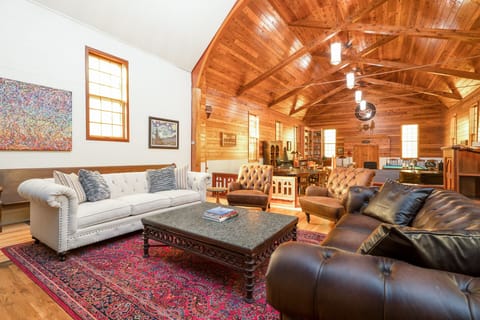 Relax in this stunning living room where soaring wood beam ceilings and rich leather seating create your perfect mountain retreat sanctuary.