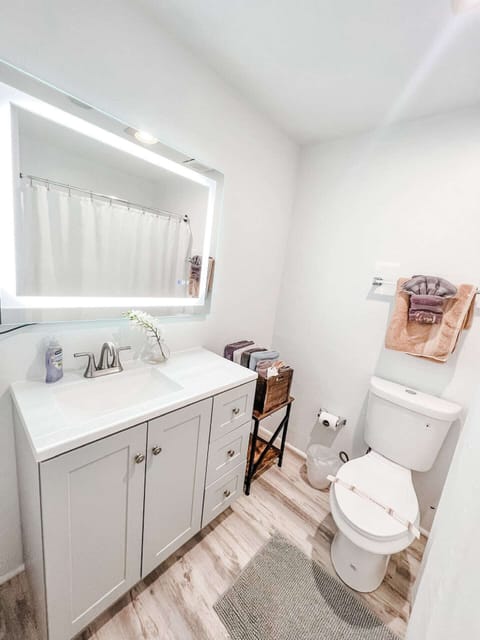 A Remodeled Full Restroom with a hair dryer, shampoo, body wash, towels, toilet paper and conditioner