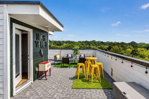 Large rooftop lounge with bar seating, patio, cornhole, and vistas