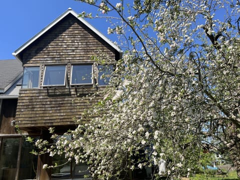 The floating two story private addition extends into the apple trees.