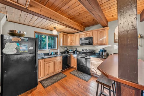 Kitchen: Electric range, drip coffee maker, toaster oven, blender, bar seating, cooking utensils, tableware