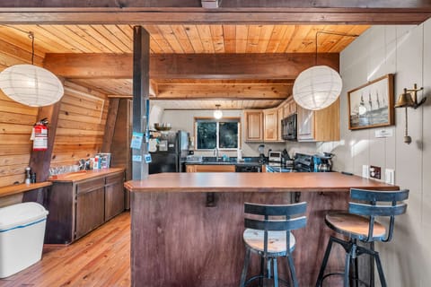 Kitchen: Electric range, drip coffee maker, toaster oven, blender, bar seating, cooking utensils, tableware