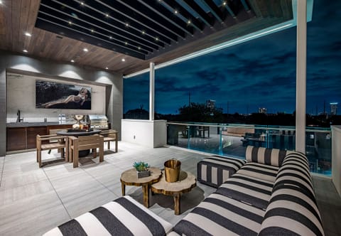 Rooftop Terrace: lounge area, dining table, and 82”tv … and downtown views