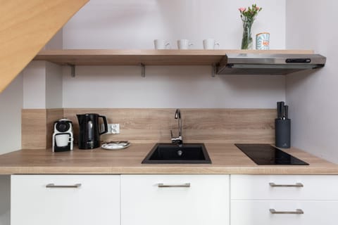 A detailed view of the kitchen counter featuring a coffee machine, kettle, and other appliances.