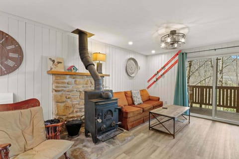 Homey retreat: A comfy couch, rocking chair, coffee table, and a smart TV set the scene for cozy movie nights. Unwind by the wood-burning stove after a day of adventure.