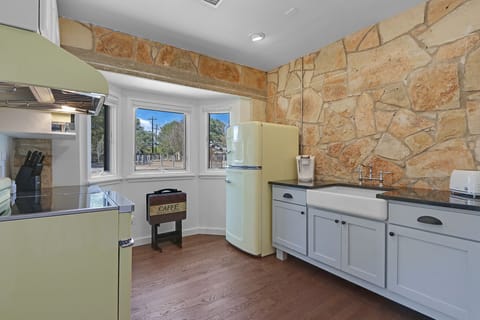 The kitchen is equipped with a stove, oven, refrigerator, and farmhouse sink