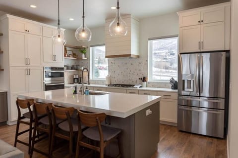 The modernly designed open living space features the living room, kitchen, and dining area and boasts beautiful hardwood floors, a stunning all-white kitchen, and a dining space flooded with natural light.