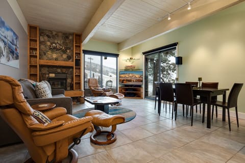 Unwind by your stone fireplace with mountain views streaming through floor-to-ceiling windows in this beautifully appointed living space.