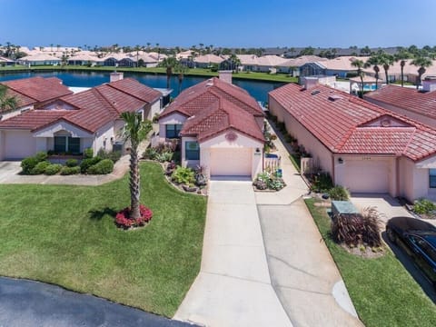 Aerial view of a lakeside suburban home with scenic waterfront access.