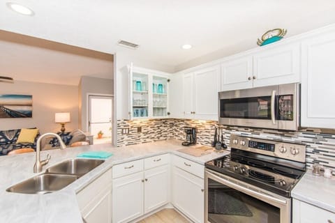 Modern kitchen with stainless steel appliances and a view into the cozy living area.